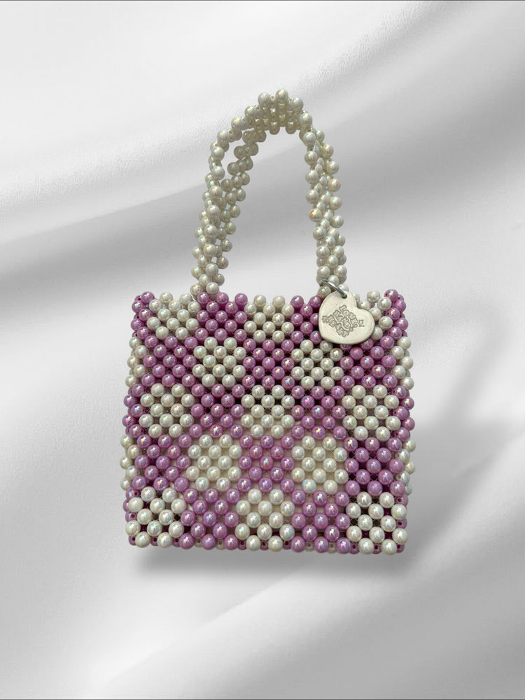 Handbag made pearl-like beads in purple and white in checkered pattern on a white background