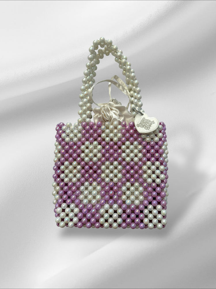 Beaded handbag with a keychain and drawstring pouch on a white background