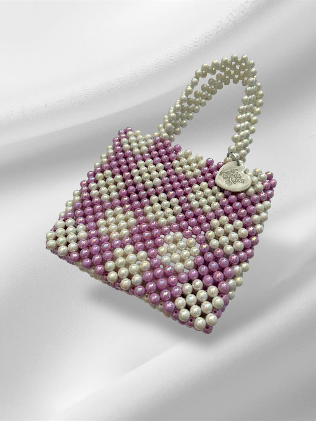 Pearl like beaded bag with lilac and white beads on a white background
