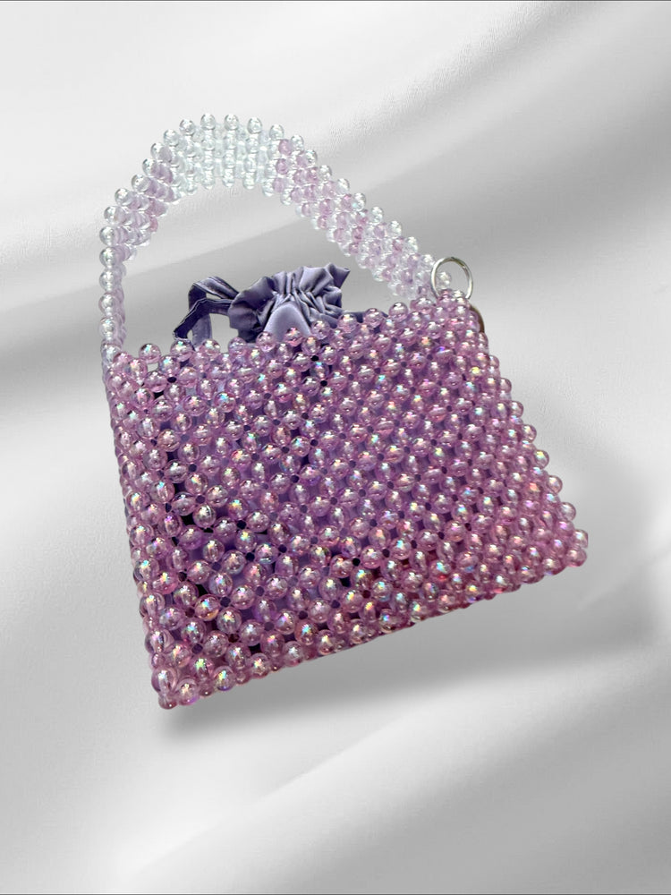 Purple beaded handbag on a white background