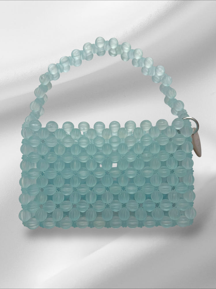 Light blue beaded handbag on a white background