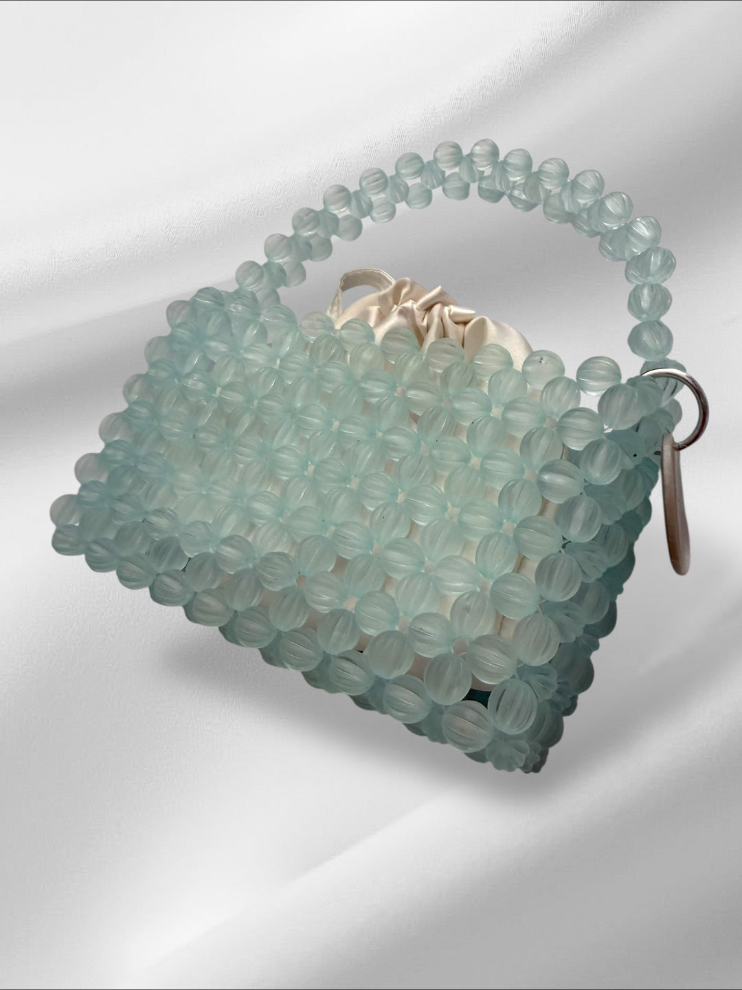 Sky blue beaded handbag on a white background