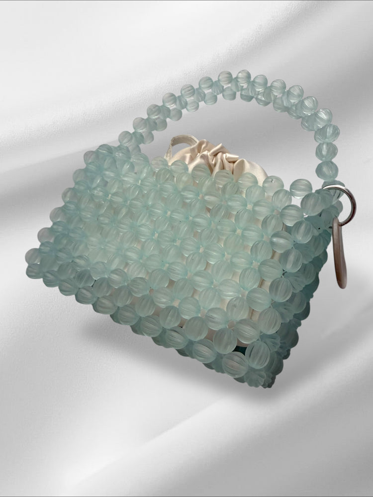 Sky blue beaded handbag on a white background