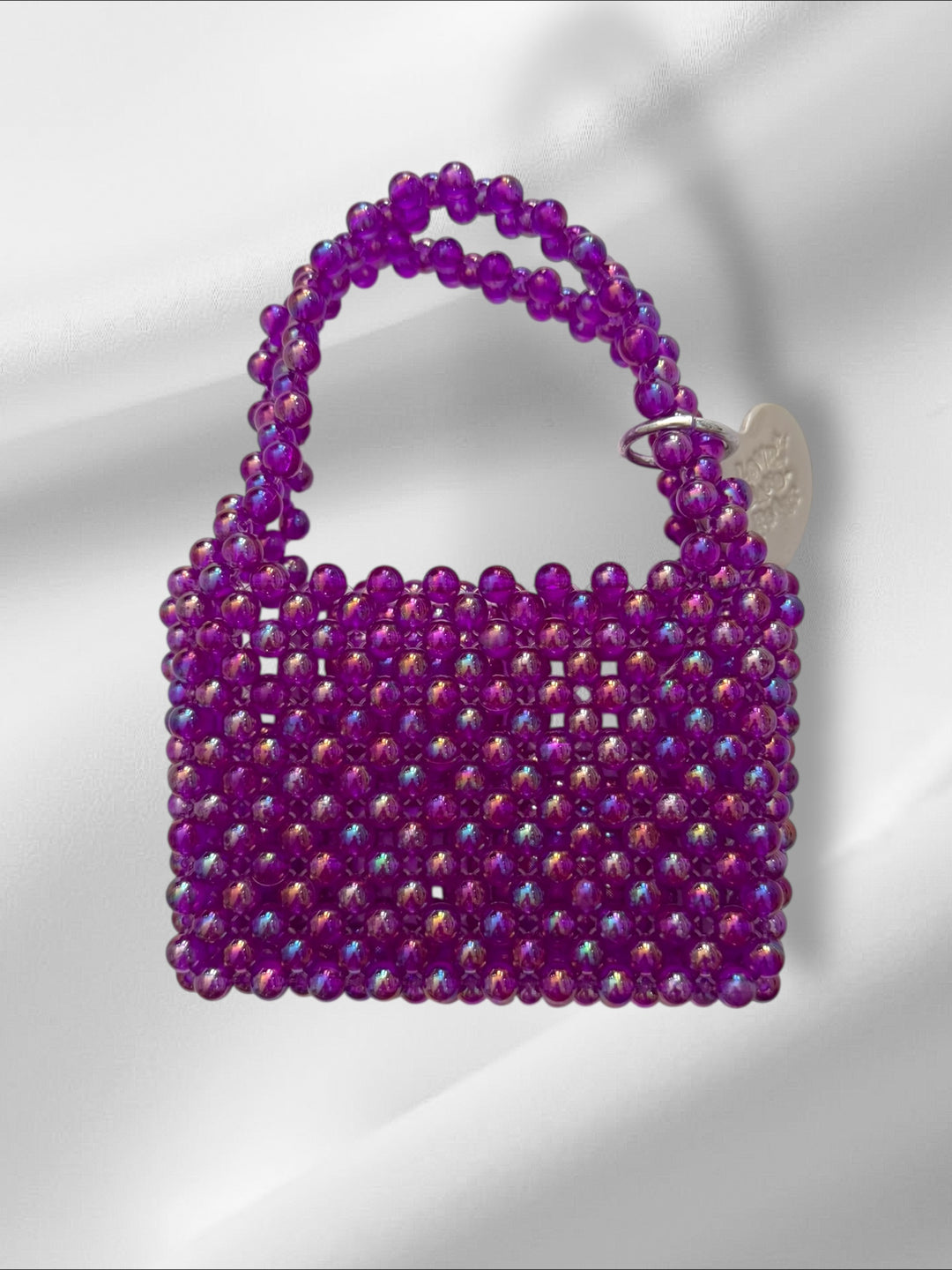 Mini purple beaded handbag on a light gray background