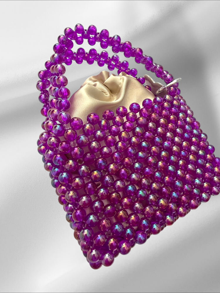 Purple mini beaded bag on a light gray background