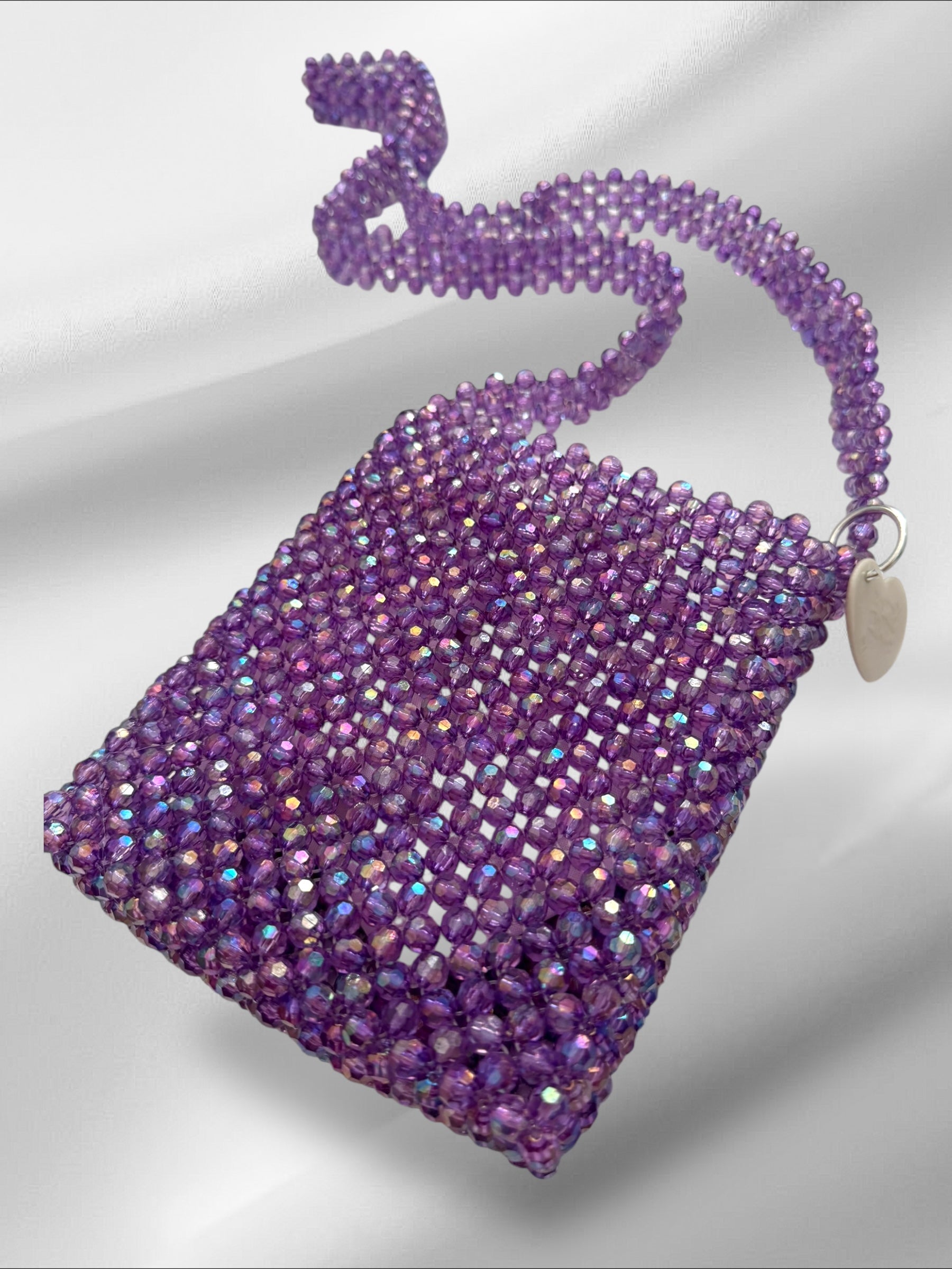 Purple beaded handbag with a hand beaded strap on a white background