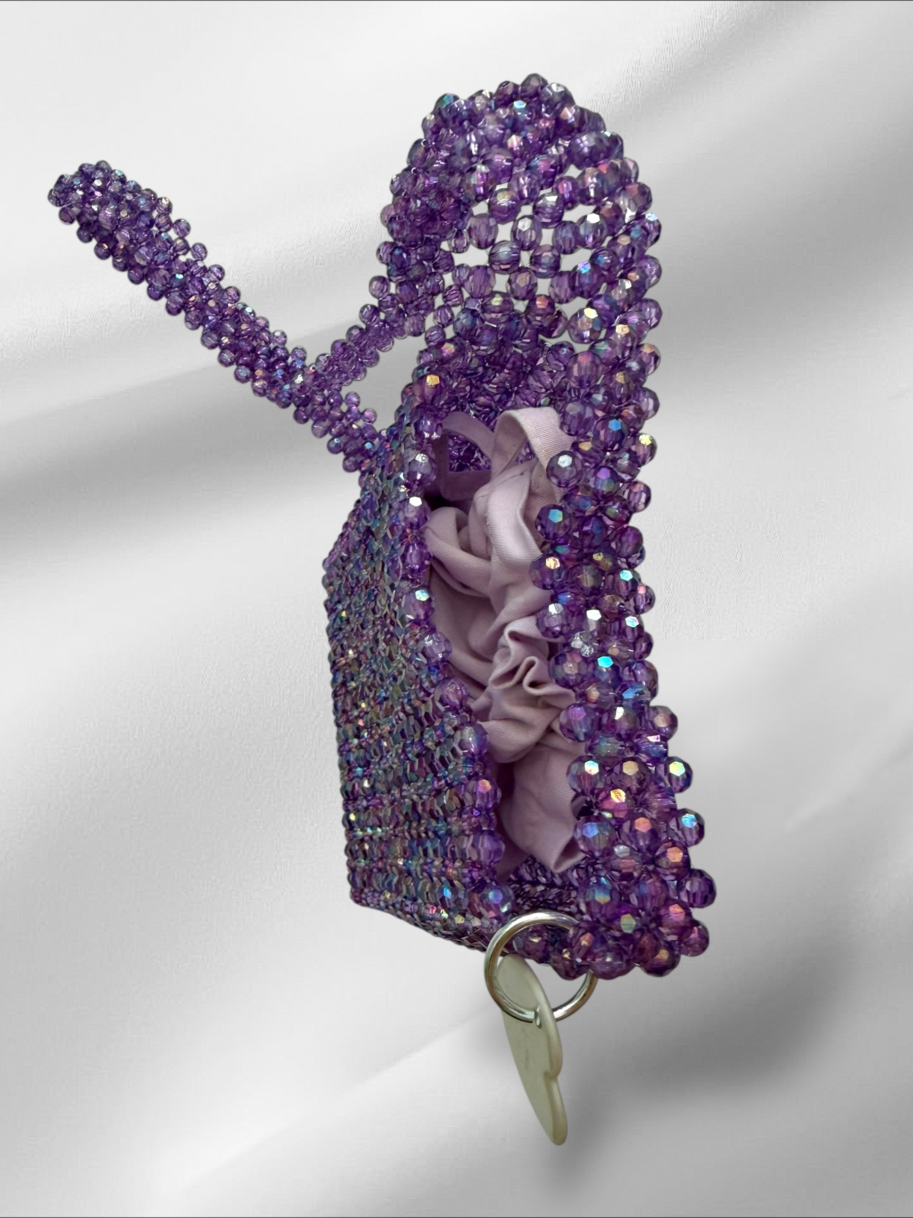 Purple beaded crossbody bag on a white background