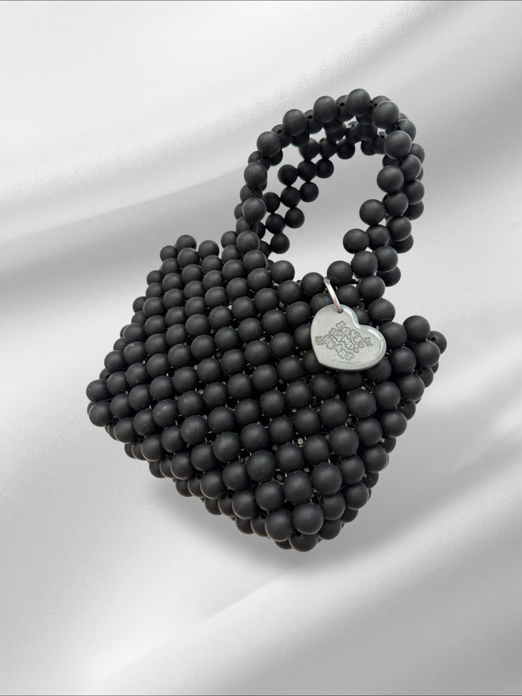 Black beaded handbag with a heart-shaped logo on a white background