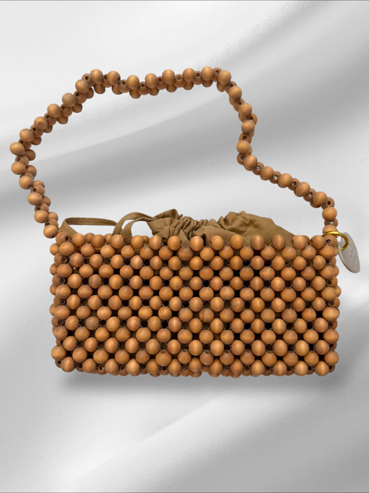 Brown beaded handbag with wooden handle on a light gray background