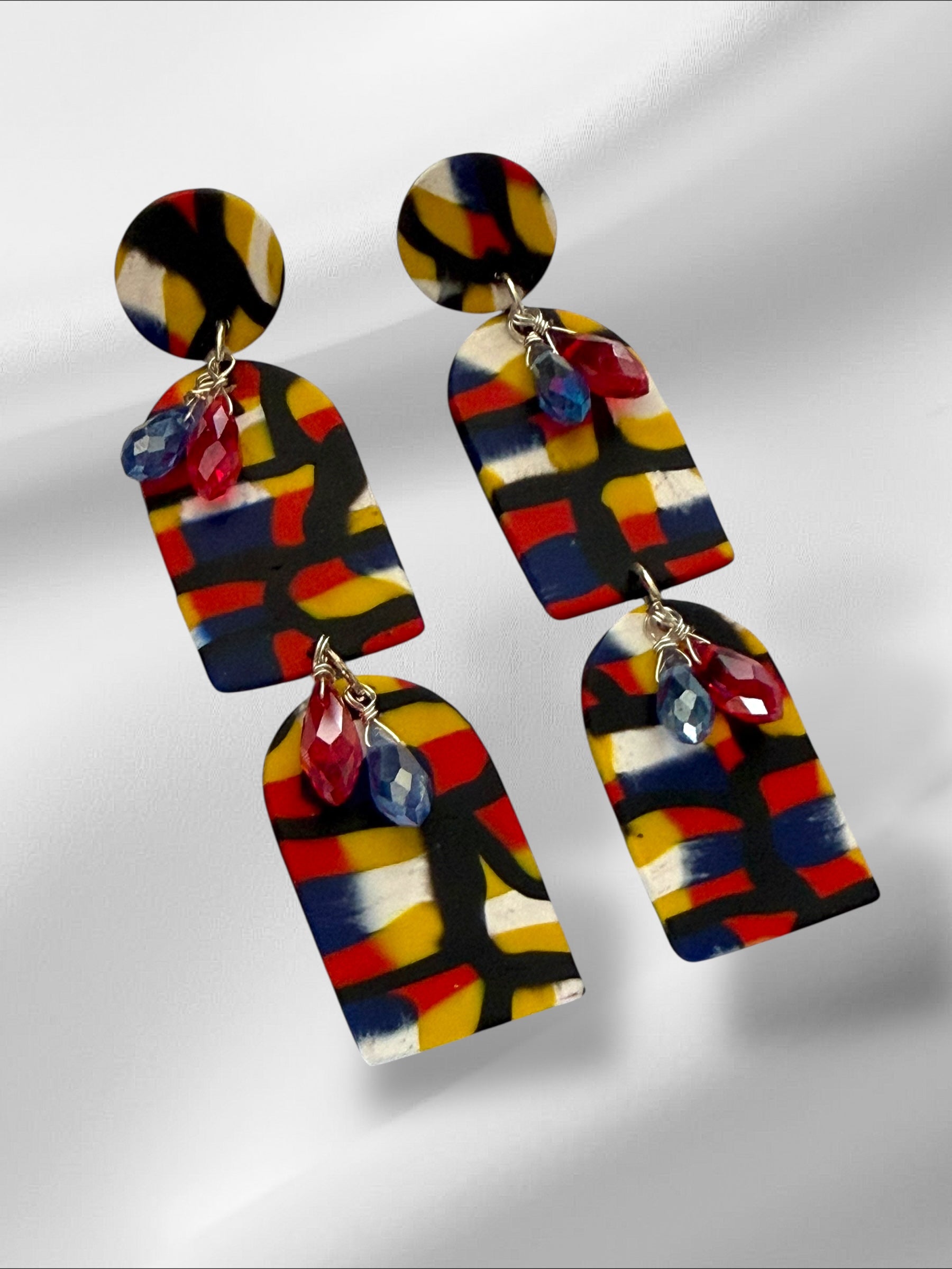 Colorful geometric patterned earrings on a light gray background