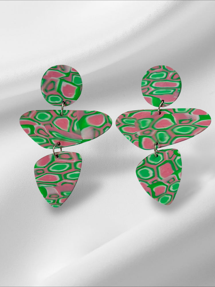 Green and pink patterned earrings on a white background