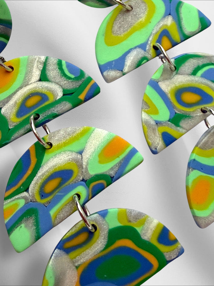 Colorful abstract-patterned earrings on a white background