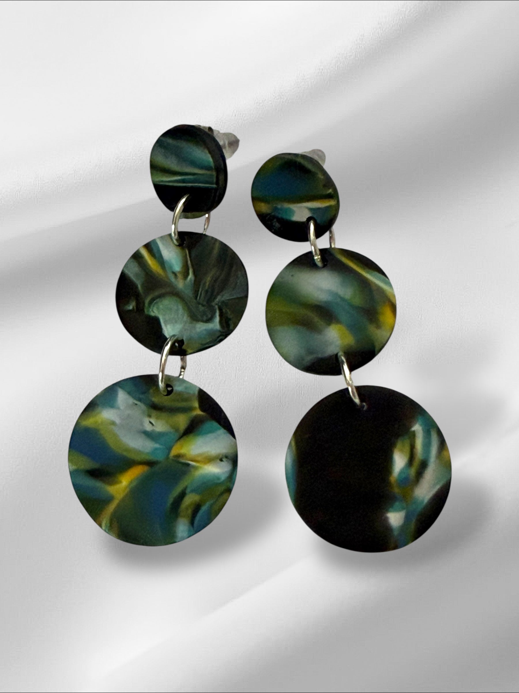 Green marbled circular earrings on a white background
