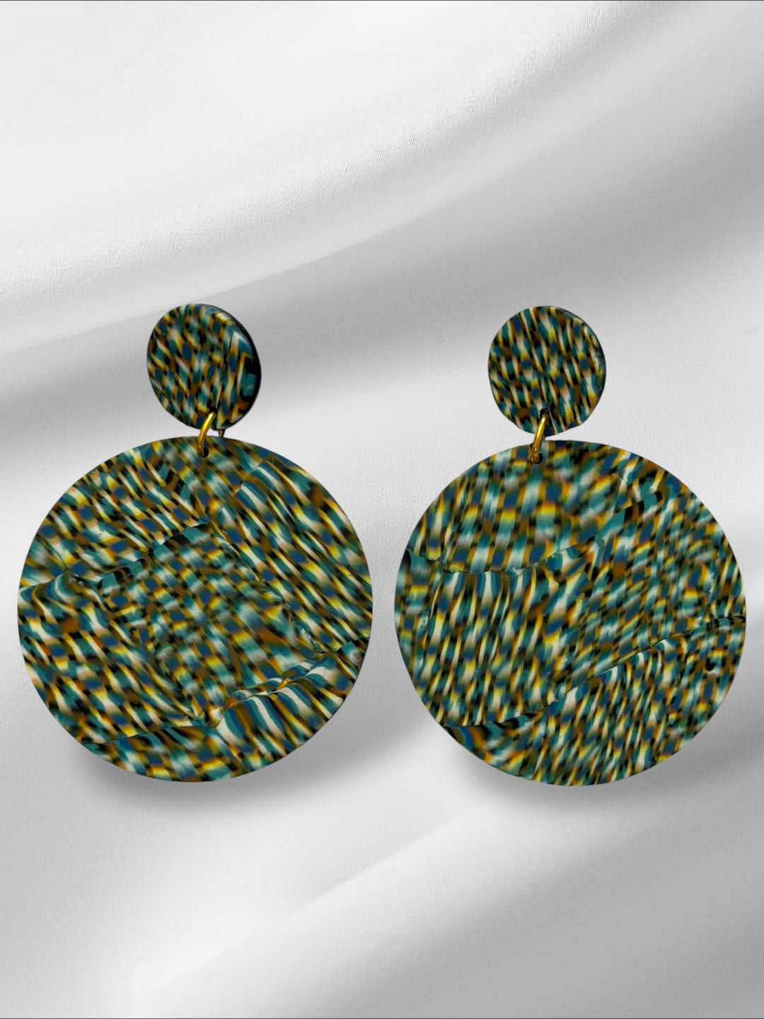 Pair of round earrings with a pattern on a light gray background