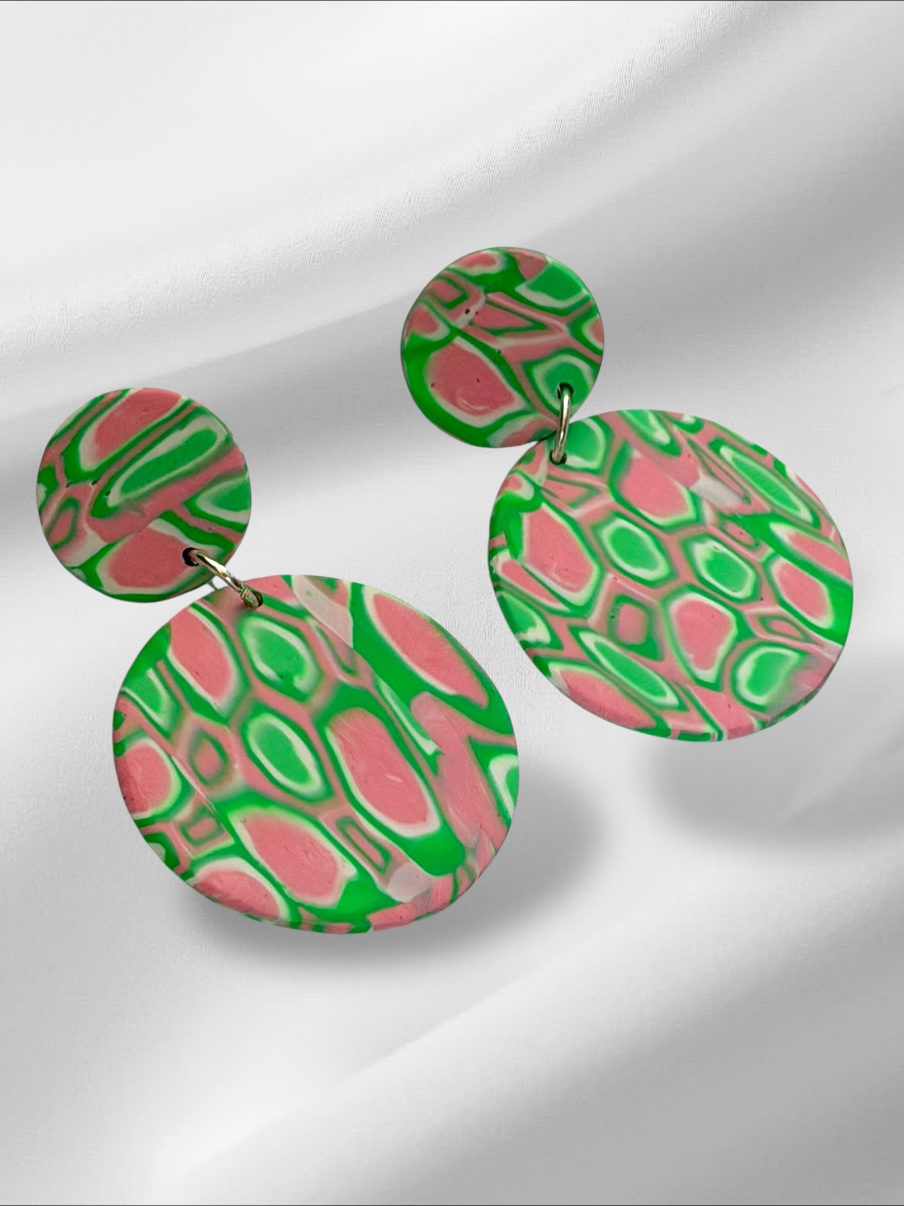 Colorful circular earrings on a light gray background