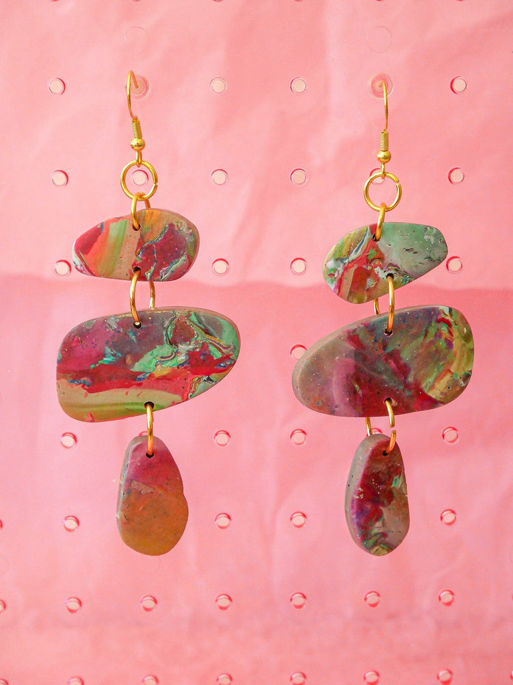 Red multicolor Marble Stackers Handmade Earrings on a pink background, emphasizing their unique color combination.