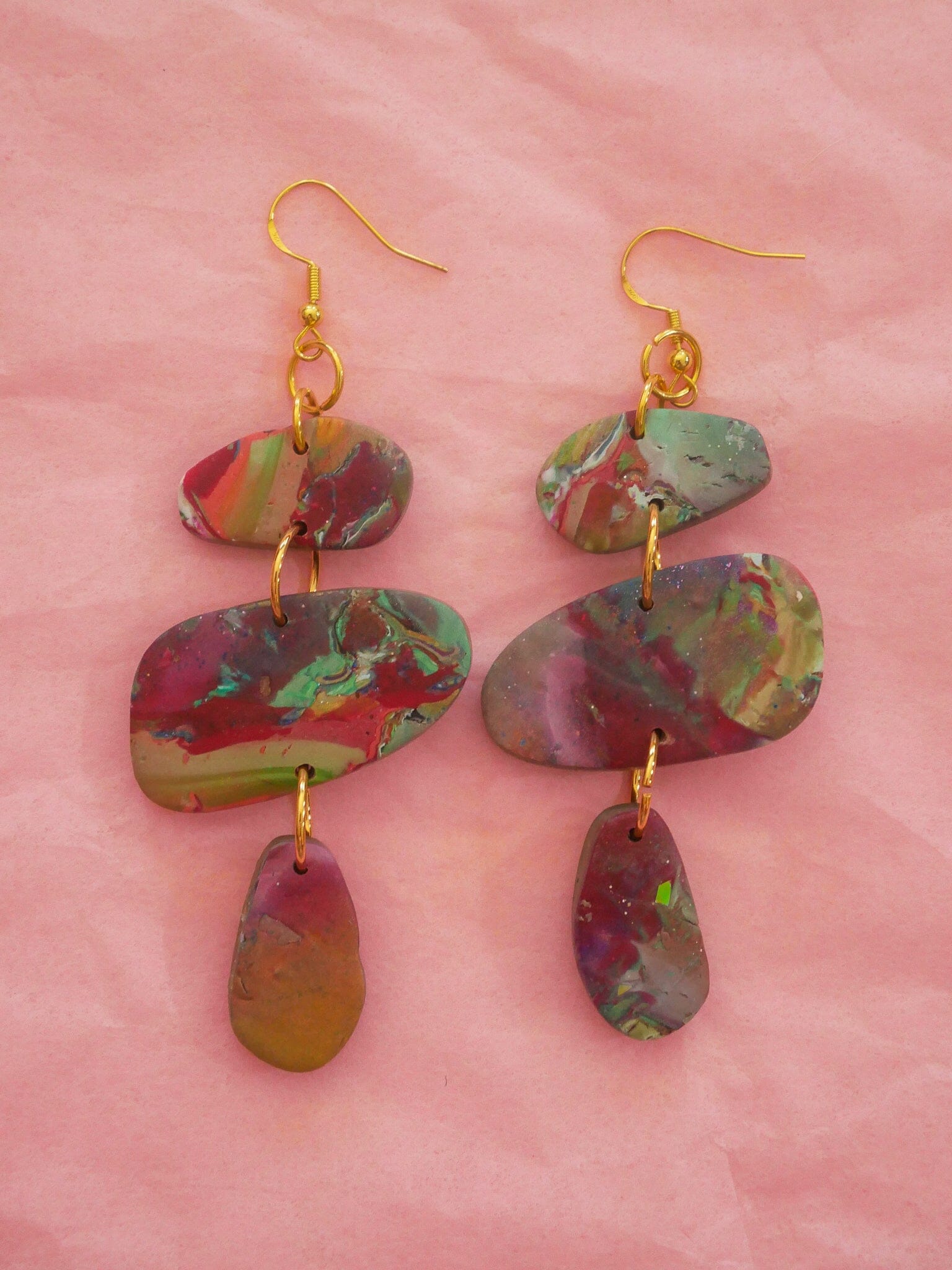 Pair of Red Marble Stackers Handmade Earrings displayed on a pink background.